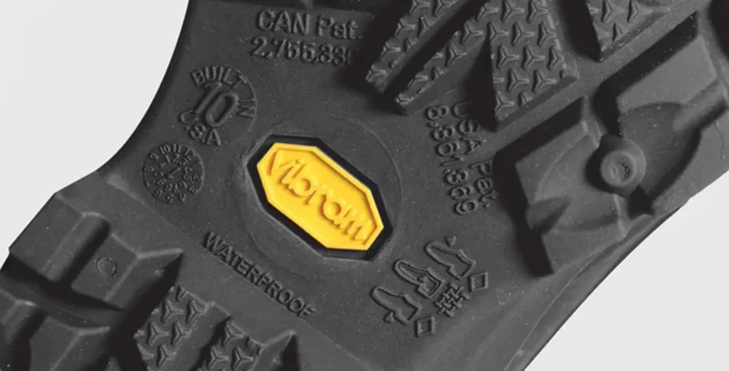 close-up of Vibram outsole on hiking boot showing traction lugs and yellow logo
